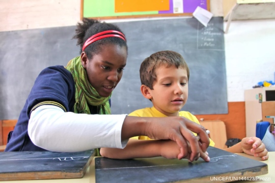 Photo of teacher teaching young boy